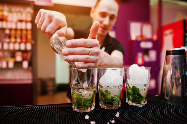 Bartender preparing mojito cocktail drink at the bar